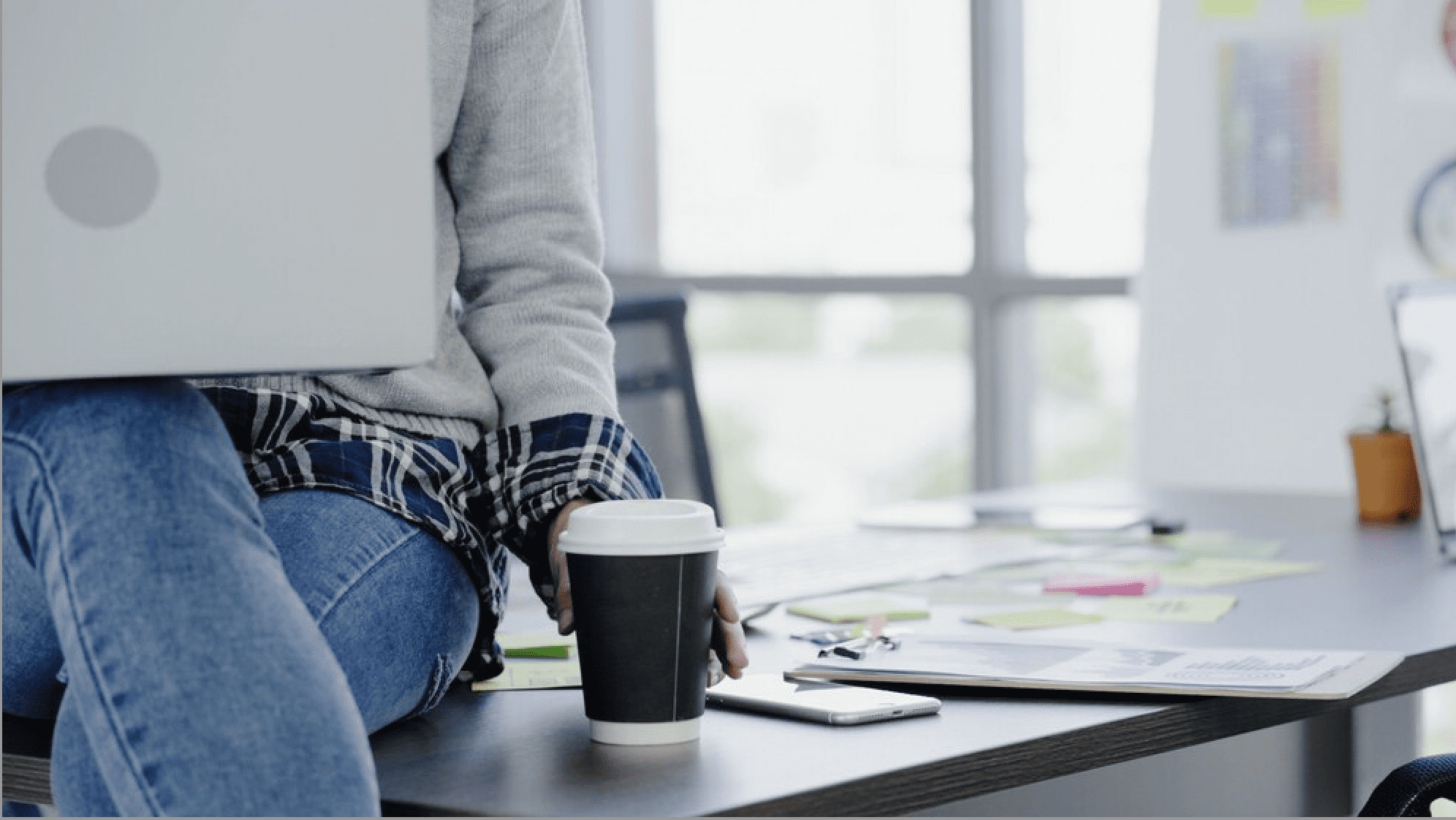 graphic designer sitting on a desk with a coffee