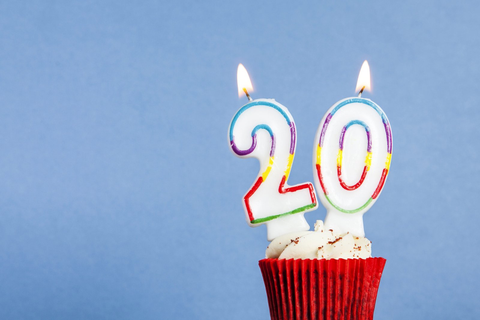 Number 20 Birthday Candle In A Cupcake Against A Blue Background